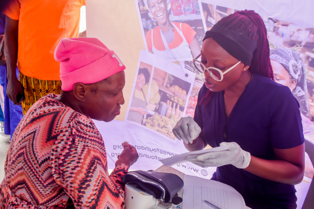An official of the foundation with a POS operator during the empowerment and medical outreach in Lagos